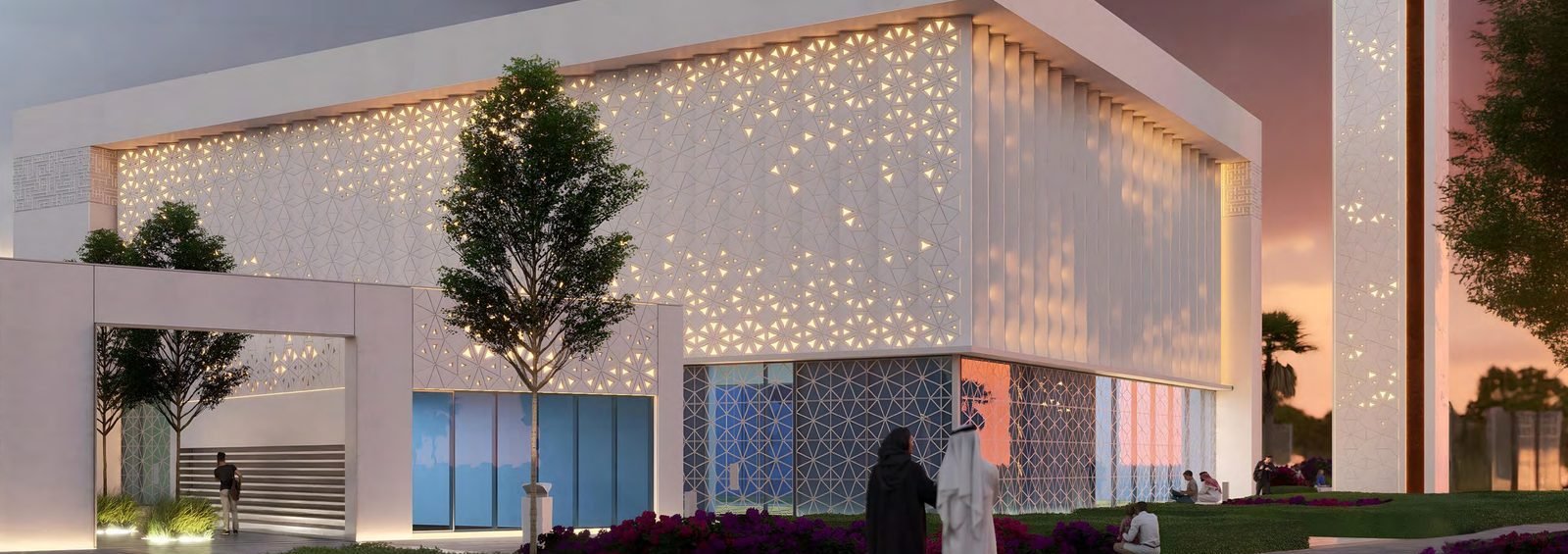 A grand mosque at Azizi Florence, its perforated stone facade lit from within at sunset.